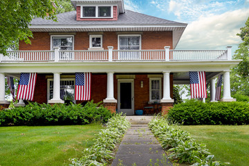 American flag decorations on front porch of old brick home
