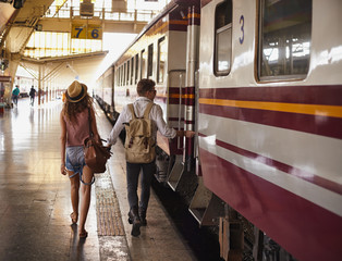 Young couple walking at the train station platform during train car