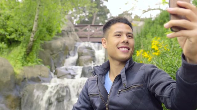 Attractive Man Takes A Selfie In Front Of A Waterfall, Then Reviews His Photos 