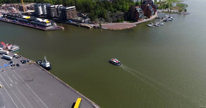 Turku harbor, Cinema 4k aerial view following a ship entering aurajoki river and the abo cityscape, on a sunny summer day, in Turku, Finland