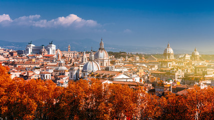 Fototapeta na wymiar Panoramic autumn view over the historic center of Rome, Italy from Castel Sant Angelo. Red foliage.