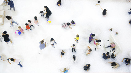group of people play and run on the white bubble playground on the top aerial view.