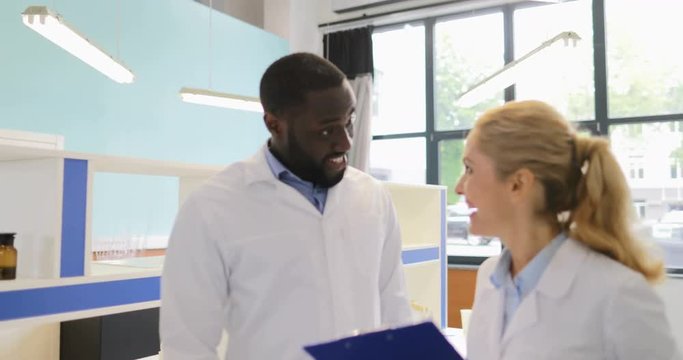 Happy Smiling Scientists Looking At Colleagues Using Laptop Computer Working On Experiment Results In Laboratory Slow Motion 60