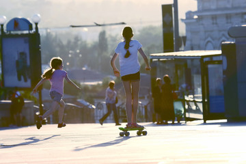 two girls actively riding and running into the street.