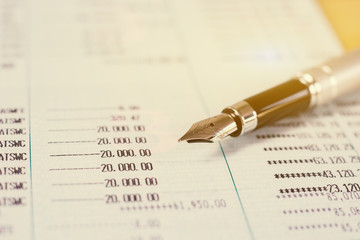 Fototapeta premium Pen with Finances statement ,hand pointing business charts,coins on paper work in the office,discussing stock marketing document,book bank