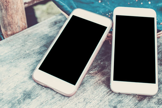 Top view image of two smartphone over wooden table room for text, ready for mockup. Empty space.