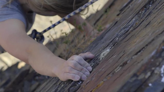 Closeup Of Female Rock Climber's Hands And Feet As She Climbs Up A Cliff Face