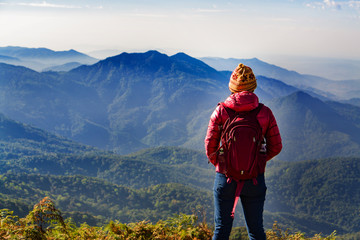 Fototapeta na wymiar Young woman traveler with backpack standing on the top of the mountain. Doi Inthanon Chiang Mai Thailand,copy space.