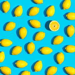 Fresh lemon pattern on a vivid blue background flat lay - obrazy, fototapety, plakaty