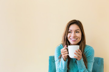 Young latina woman drinking coffee while sitting