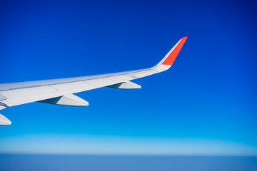 View of plane wing with blue sky.