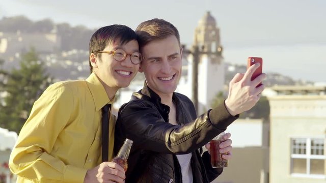 Happy Gay Couple Take A Photo Together On A Rooftop With City View 