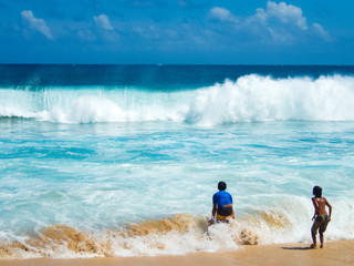 10 year old boys play in  surf, Shipwreck Beach near Grand Hyatt, Koloa, Poipu, Kauai, Hawaii, USA