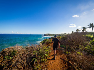 Fototapeta na wymiar 10 year old boy hiking on Maha' elepu Heritage Trail, near Shipwreck Beach and Poipu Golf Course, Koloa, Kauai, Hawaii, USA
