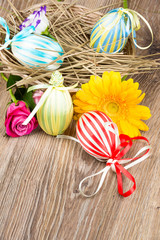 Easter eggs with flowers on wooden background
