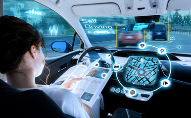 young woman reading a book in a autonomous car. driverless car. self driving vehicle. heads up...