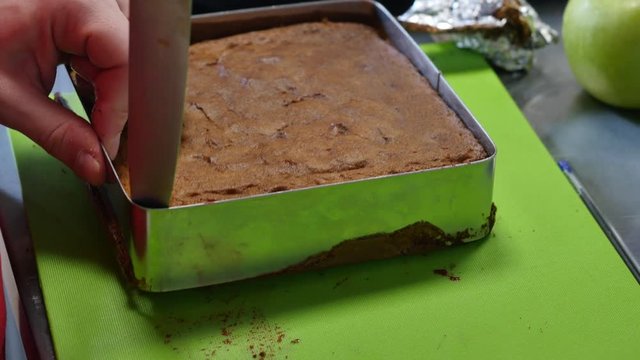 Cook taking out layer cake from cake form. Cooking cake