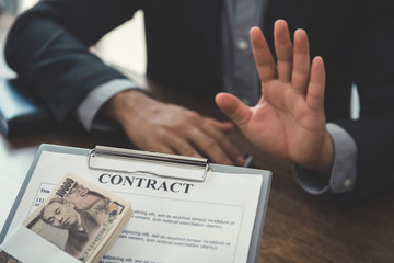 Businessman rejecting money that come with  contract