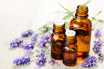 Obraz na płótnie Canvas Lavender essential oil in the amber bottle, with fresh lavender flower heads.