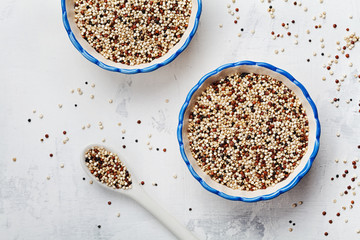 Mixed quinoa in bowl on stone kitchen table top view.