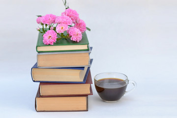 Books and flowers on a white background.