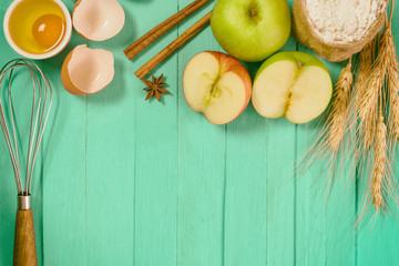 Bakery background comprise apples,wheat flour,egg and cinnamon on blue wood table with copy space.Prepare ingredient for baking apple cake on wood table. Top view bakery background concept.