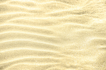Golden glitter on sand background