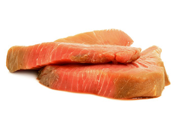Two uncooked, raw tuna fish steaks isolated on a white background