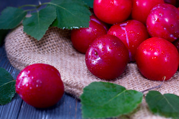 Red plums on wooden table