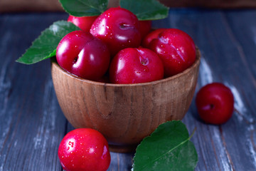 Fototapeta na wymiar Red plums on wooden table
