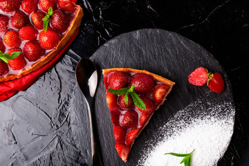 Strawberry pie on black slate plate. One piece. Top view.