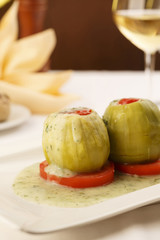 Stuffed zuchini arranged on a plate, Wineglass in the background, Traditional dish in elegant setting, Selective focus with soft light