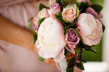 Beautiful wedding bouquet in hands of the bride