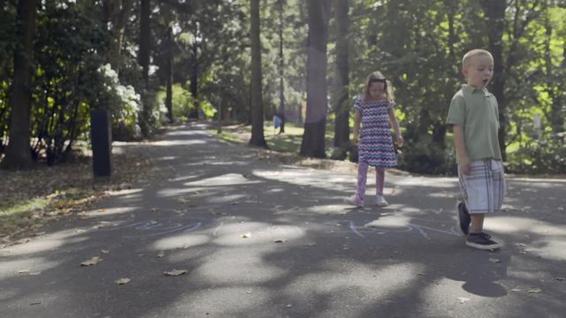Little Kids Walk Down Path In Park, Explore On Their Own (Slow Motion)