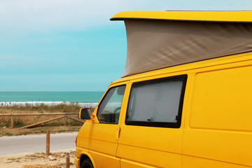 Yellow van parked on the beach