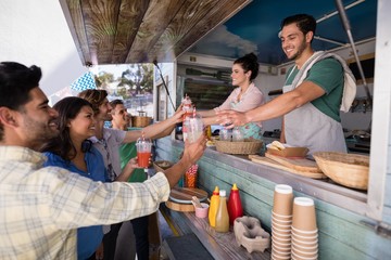 Waitress and waiter giving juice to customer at counter - Powered by Adobe
