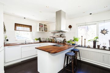Fototapeta na wymiar stylish kitchen interior with dark wooden floor white cupboards