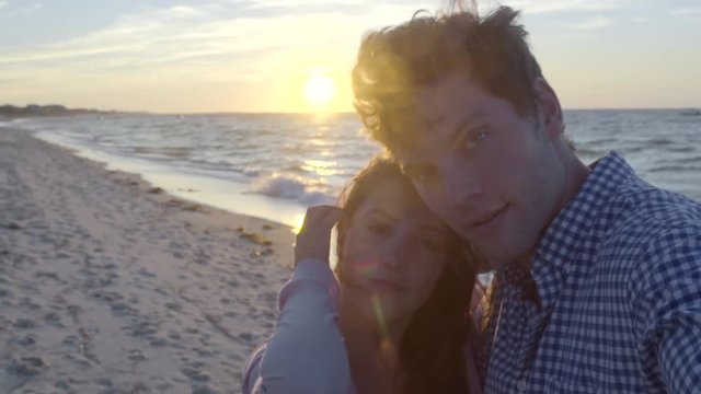 Attractive Couple Take Selfies On Beach At Sunset