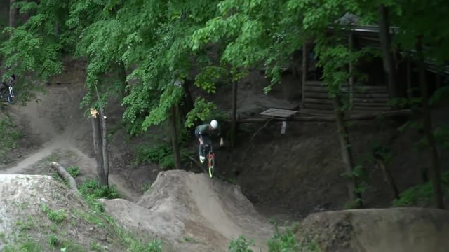 Man jumping on bike on the hills in the forest slow motion