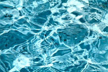 Swirling swimming pool cyan water.  Light spots and waves.