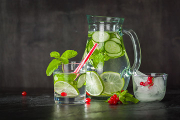 Water detox in a glass jar and a glass. Fresh green mint and berries. A refreshing and healthy drink.