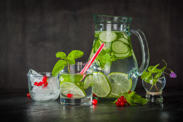 Water detox in a glass jar and a glass. Fresh green mint and berries. A refreshing and healthy drink.