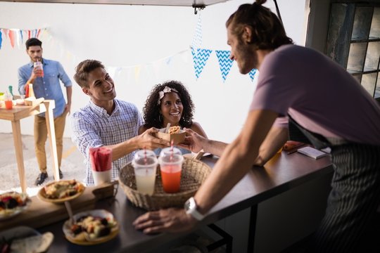 Waiter serving snacks to customers