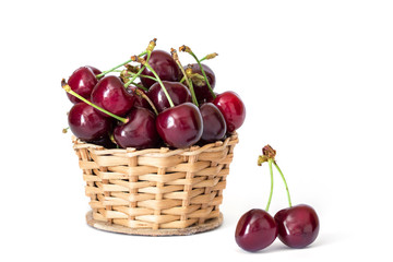 Couple connected cherries and basket of sweet red charries on a stem