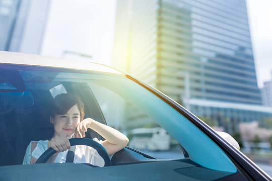 Young Woman Driving A Car In The Urban City.