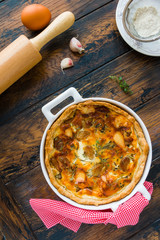 Tart with caramelized garlic, rosemary and thyme, puff pastry. Wooden rustic table, top view.