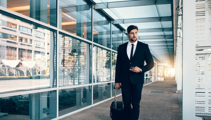 Fototapeta premium Business traveler with suitcase at airport