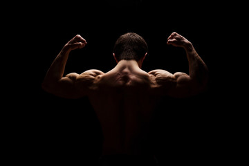 Strong muscular man showing his hands, shoulders, neck, bicep and back muscles. Fitness concept....