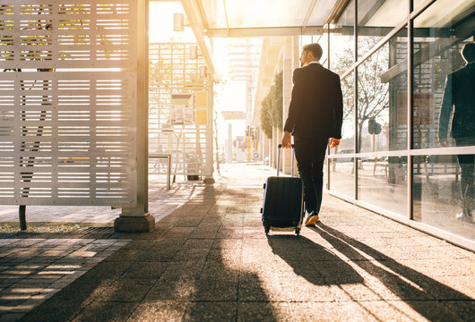 Businessman walking with bag outside airport