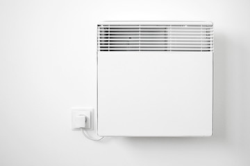 Modern white electric radiator on the wall - obrazy, fototapety, plakaty